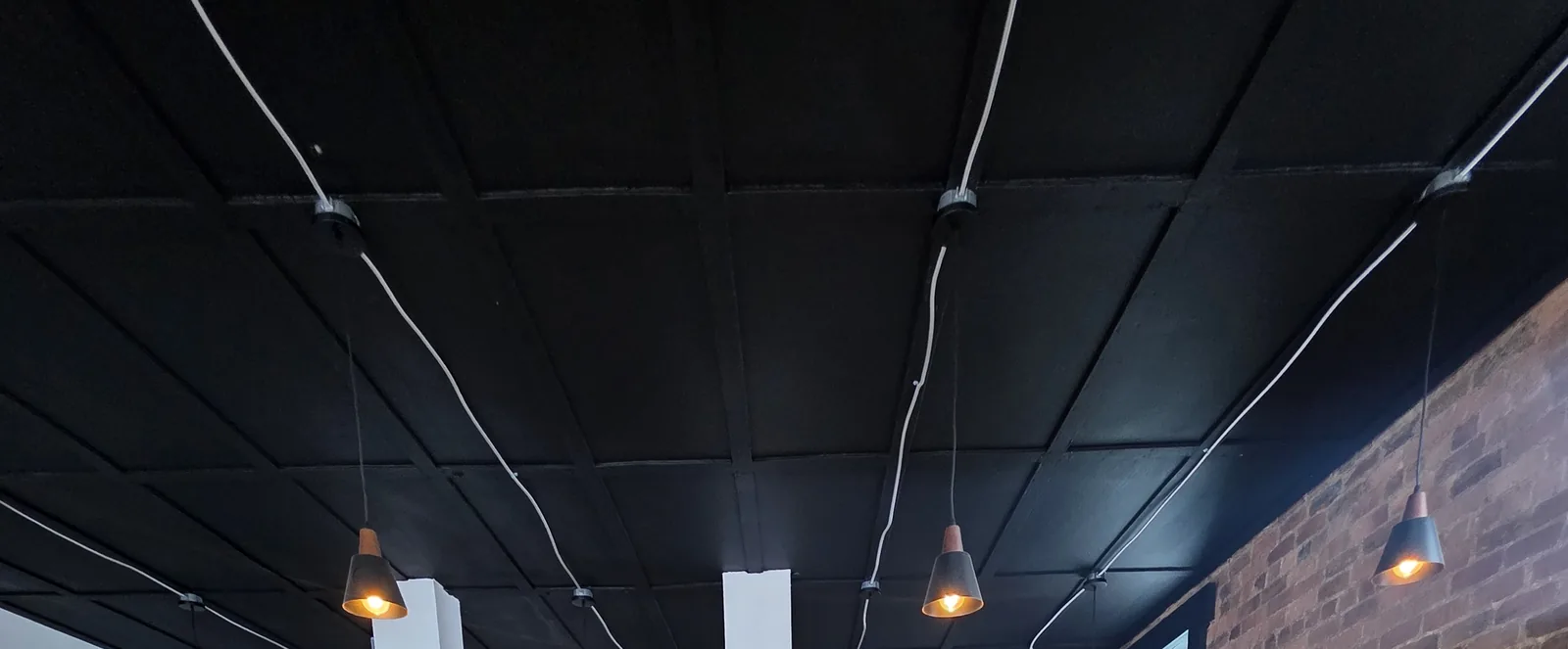 Black panelled ceiling and pendant run